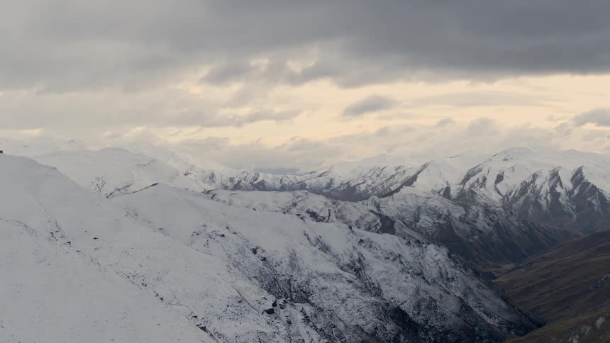 The mountains are covered with snow on a cloudy day