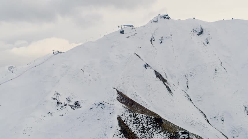 Snowcovered mountain landscape with a chairlift visible at the top