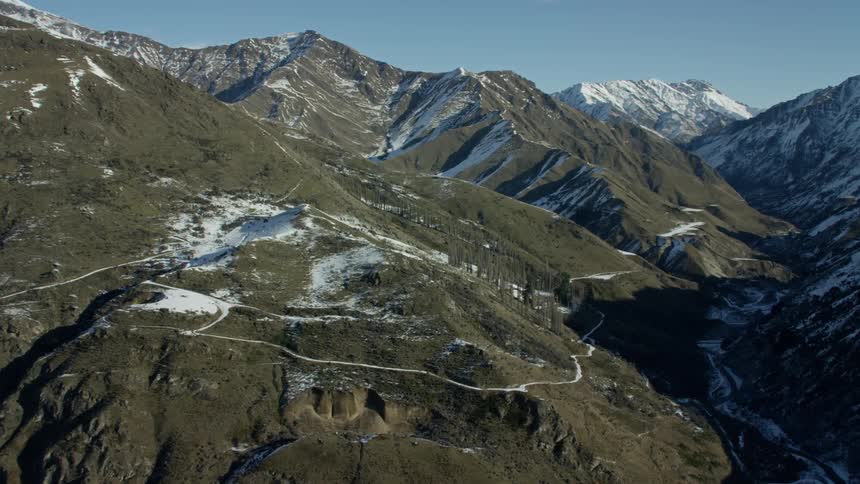 Aerial view of rocky mountain peaks against a blue sky