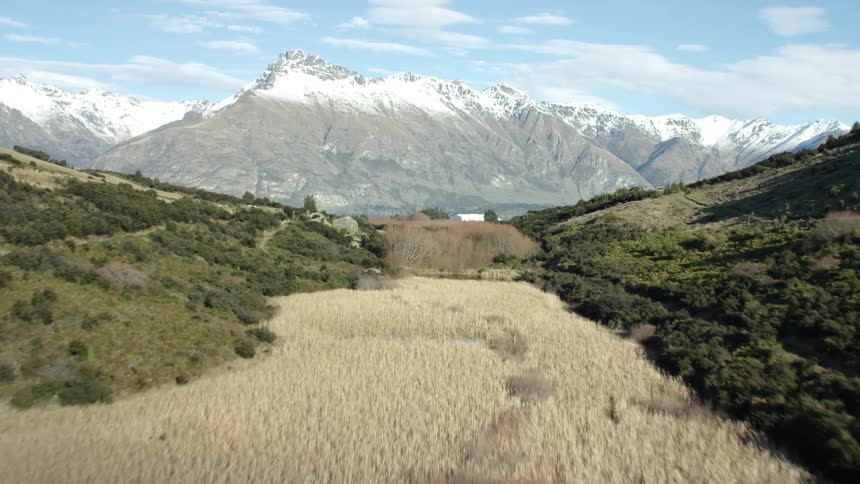A landscape of a region with a lake and in the background there is a huge mountain covered in ice with another lake at its base