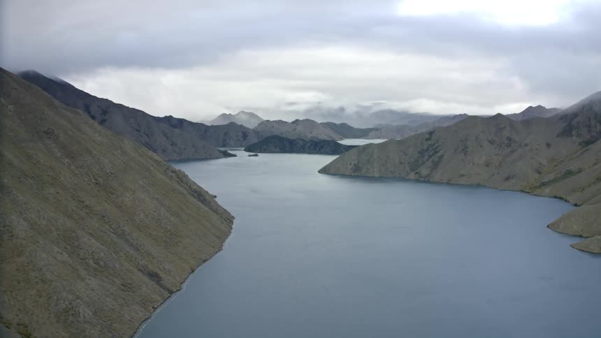 Flying towards the approaching storm across a calm lake