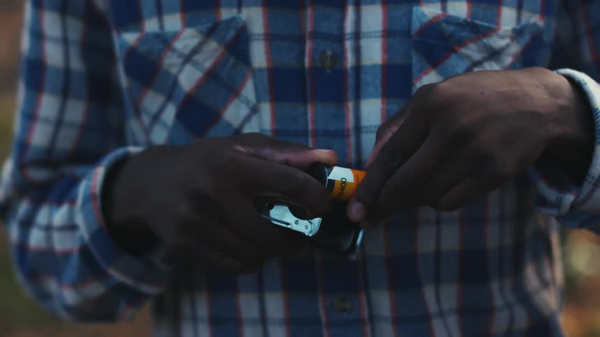 A young man loads film 35mm film into his camera