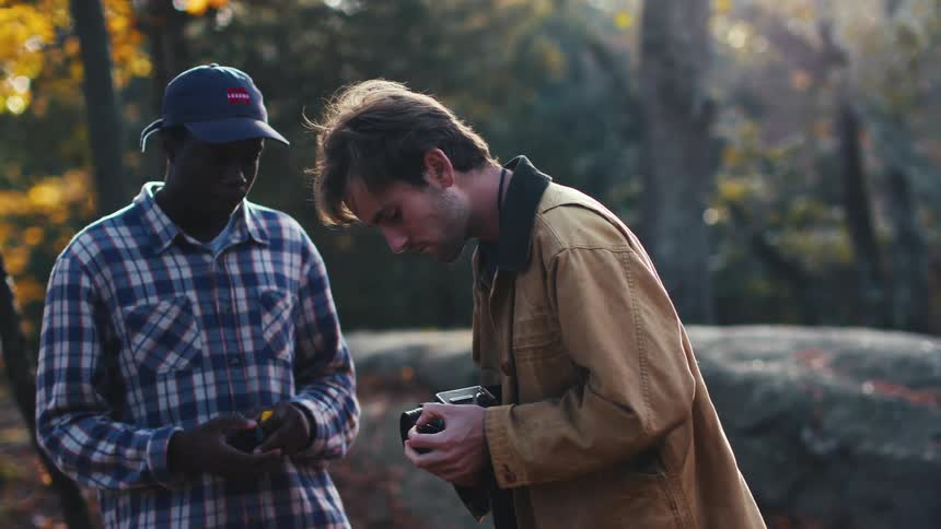 Two friends load film into their vintage cameras