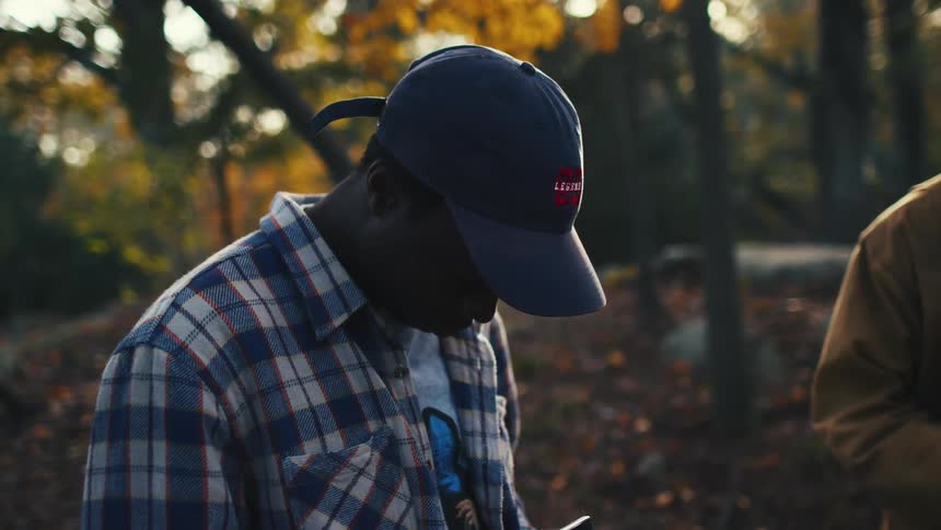 A young man photographs the fall colors on his film camera