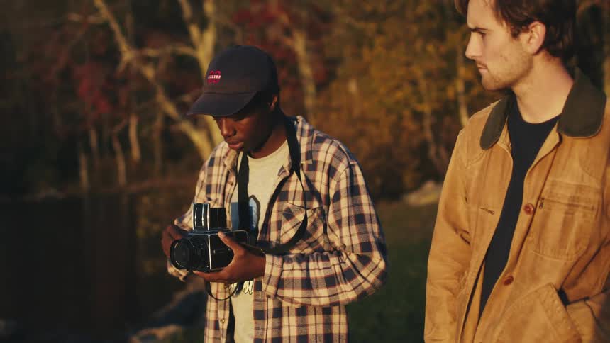 A young man photographs the fall colors on his Hasselblad film camera