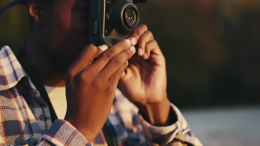 A male photographer takes pictures on a film camera