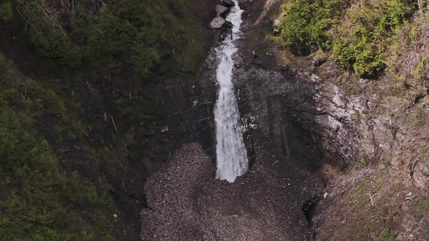 Aerial view of a stunning waterfall falling into a rocky basin