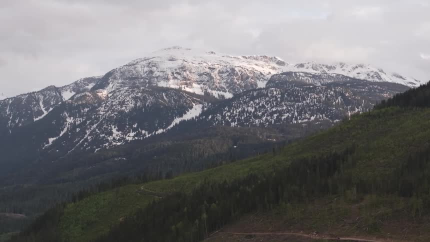 Aerial view of a snowcovered mountain range under a cloudy sky