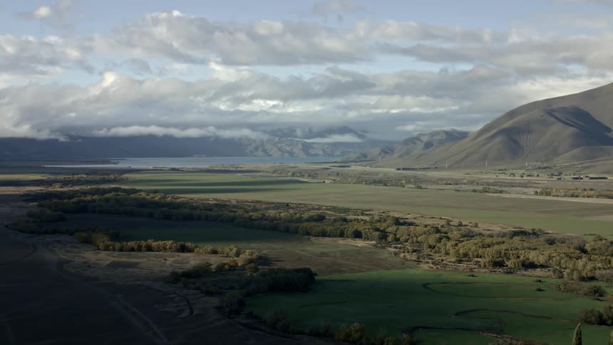 Aerial view of a vast valley with rocky terrain flanked by steep mountains