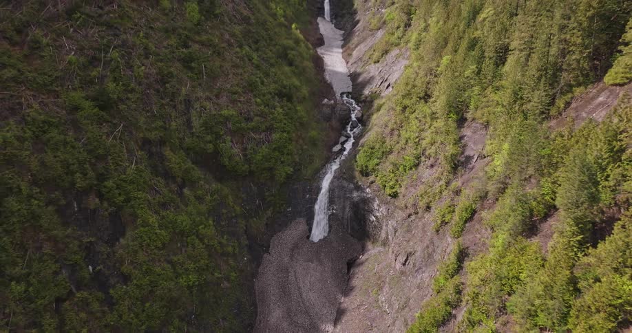 Aerial view of a winding waterfall amid dense vegetation