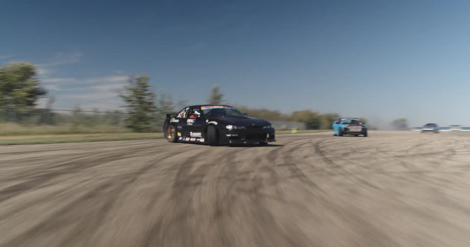 Aerial view of race cars drifting on a track