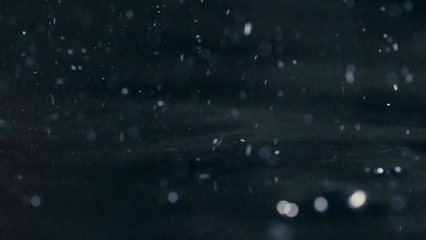 Closeup droplets of water on a dark reflective surface