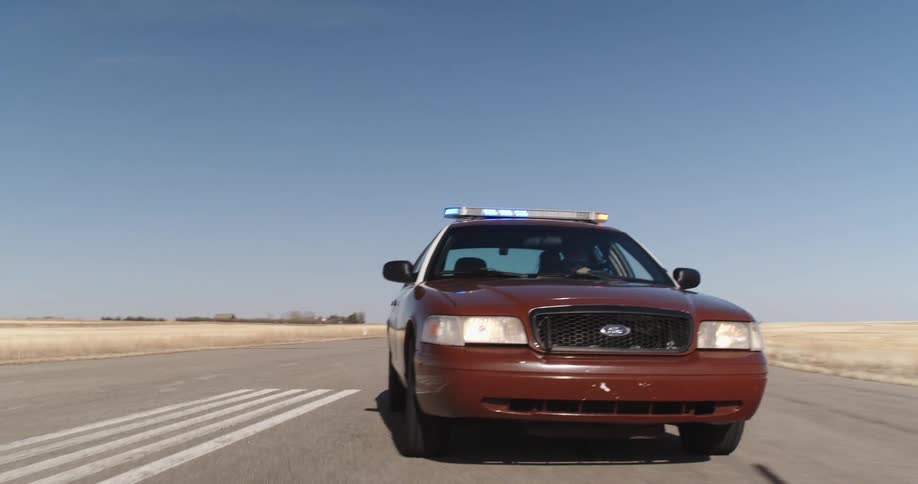 Police car moving on a road with emergency lights on