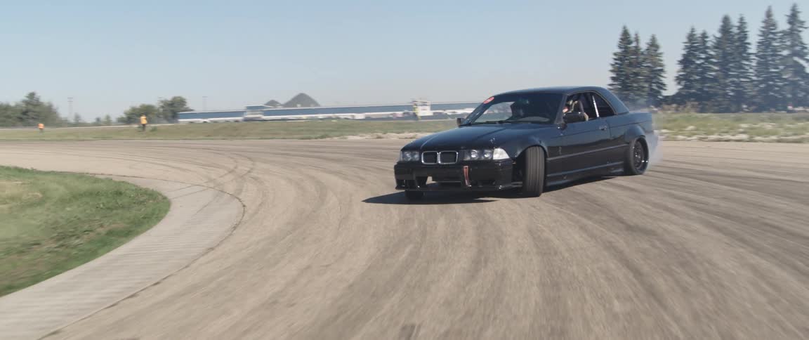 Black sports car doing a drift maneuver on a track