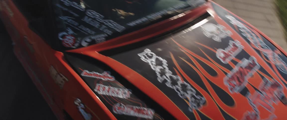 A red racecar is focused on with other cars behind it during a race as the camera zooms in and out chaotically