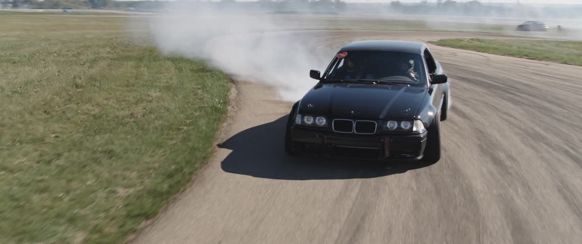Black sports car doing a drift maneuver on a track