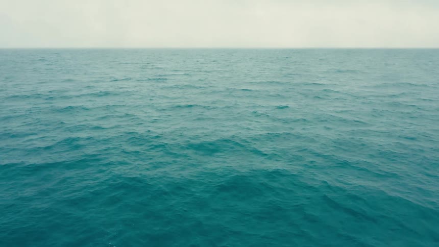 Vast calm blue ocean under a cloudy sky