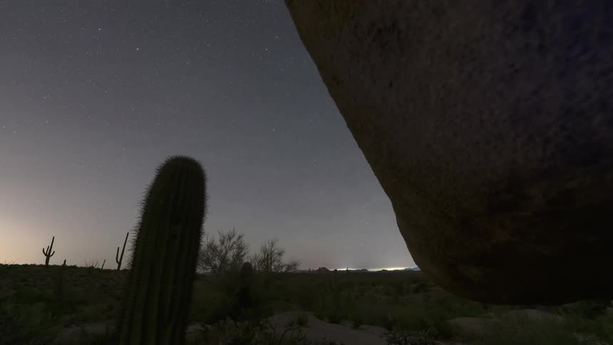 A night sky filled with stars above a desert landscape
