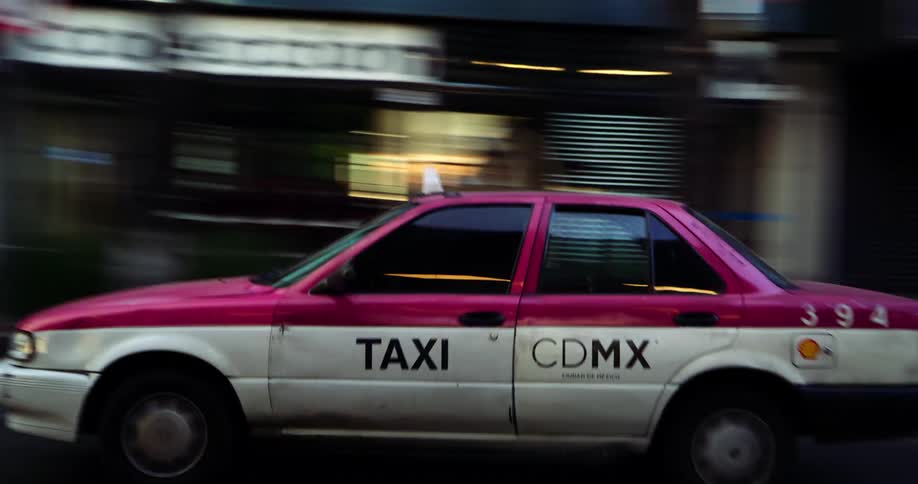 Mexico city taxi moving on an urban street with buildings around