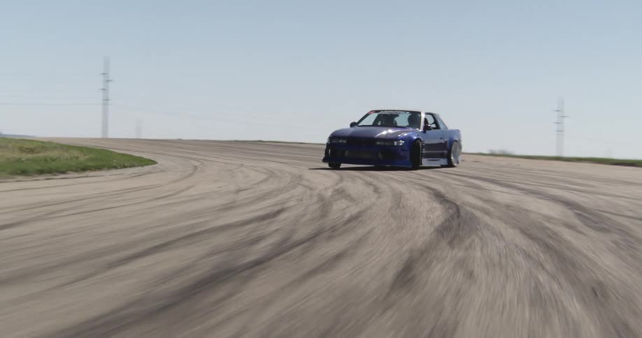 Aerial view of a blue race car drifting on a track