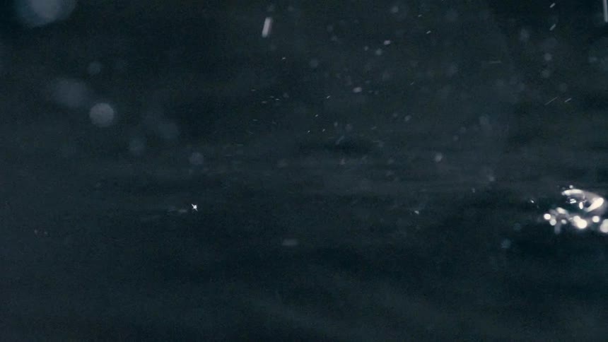 Small water droplets falling on a water surface in a dark environment