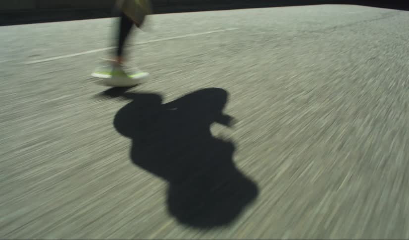 Shadow of a person running on a road outdoors