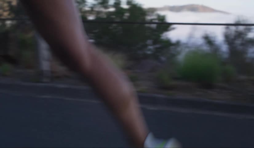 A woman jogs on a road near a mountain valley