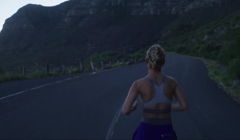 A woman is running on the mountain road