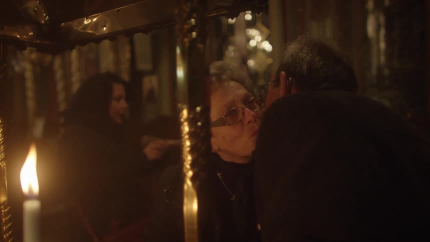 Elderly couple kissing in front of a candle