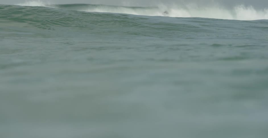 A surfer spins his board up into the air as he rides a wave