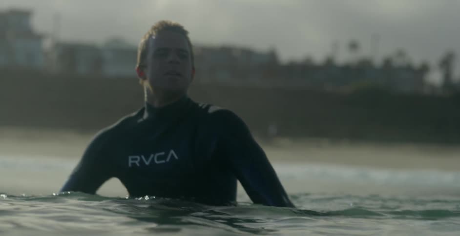 Surfer resting on his board out in the water