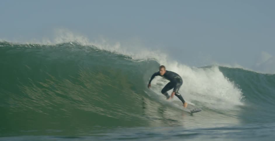 A surfer begins to ride and then crashes into a wave