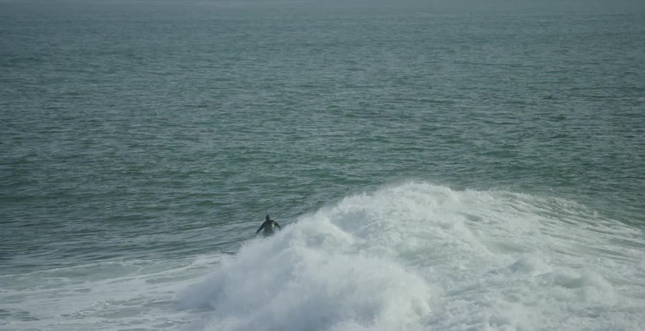 A surfer rides a wave in the ocean