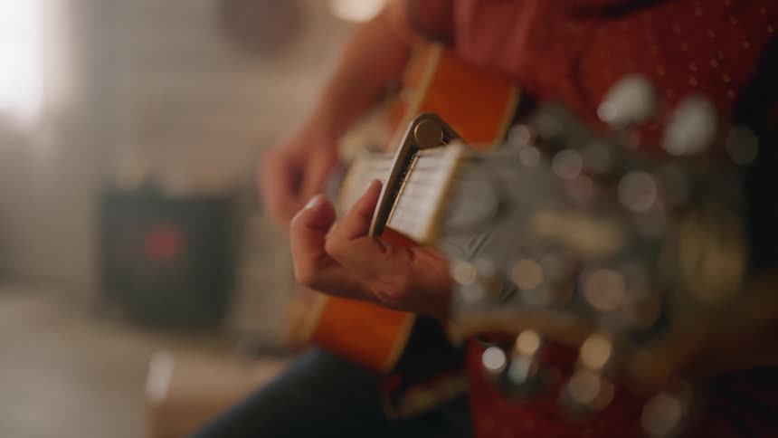 A mans hands playing guitar