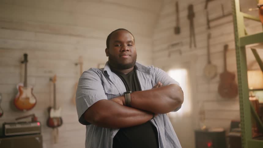 Musician with arms crossed in a music studio