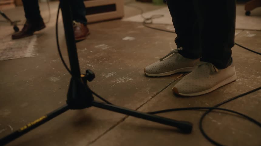 Two musicians tap their feet while making music