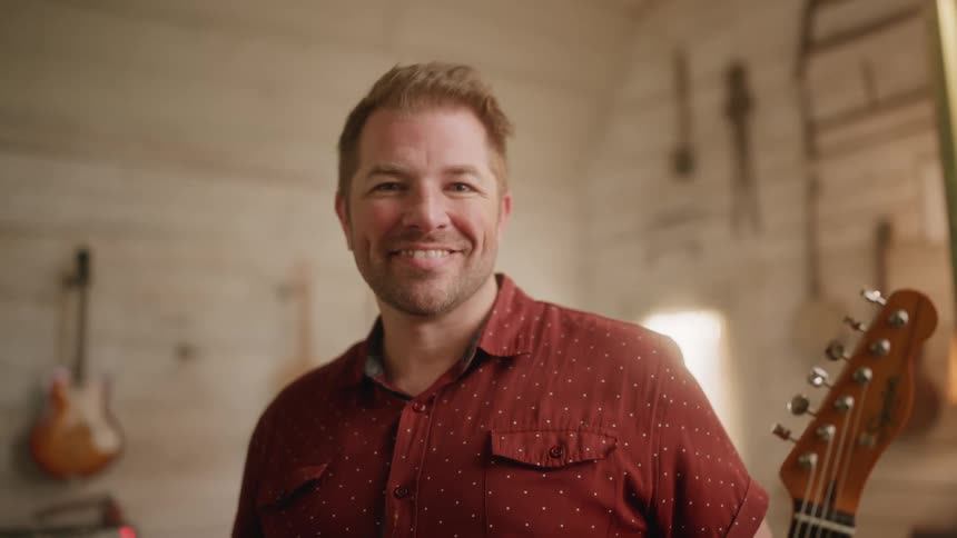Smiling man in a musical environment with a guitar