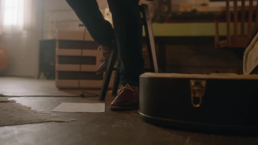 A man's foot tapping to the music as he plays his guitar