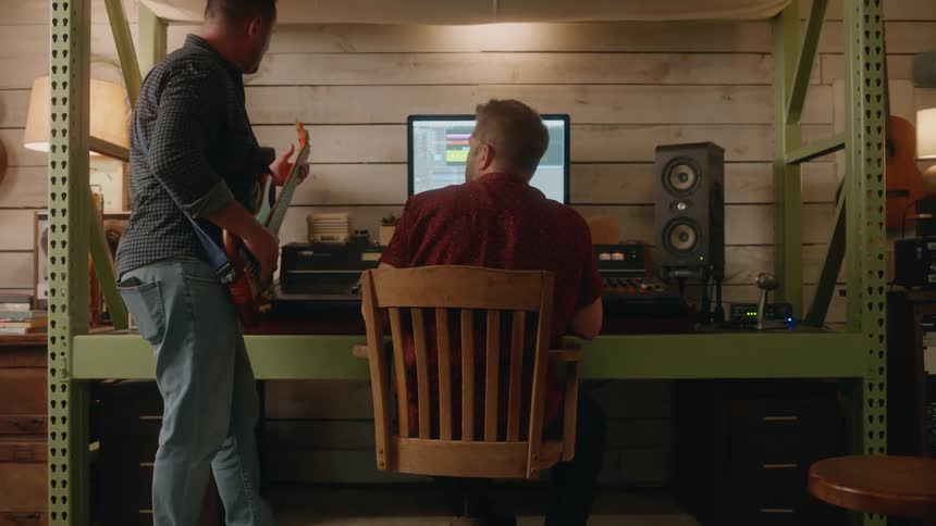 A footage of two people making music indoors