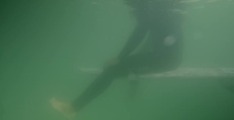 A man sits on a surfboard in the ocean