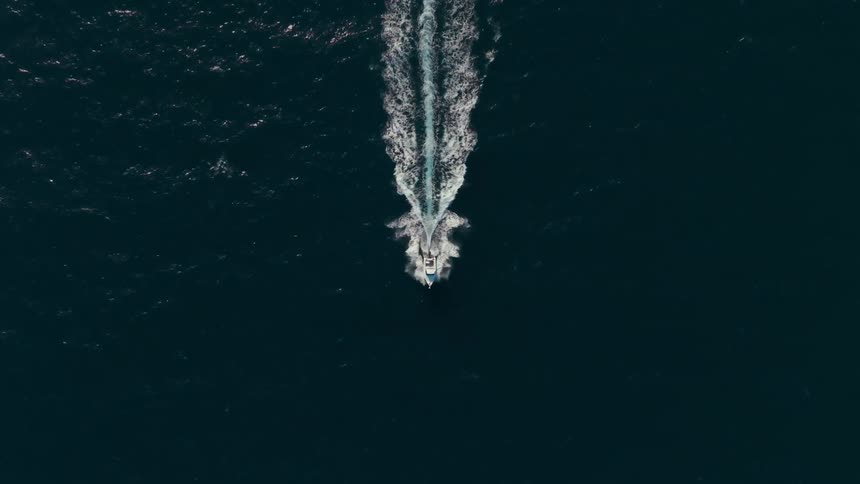 Aerial view of a boat passing in a vast ocean