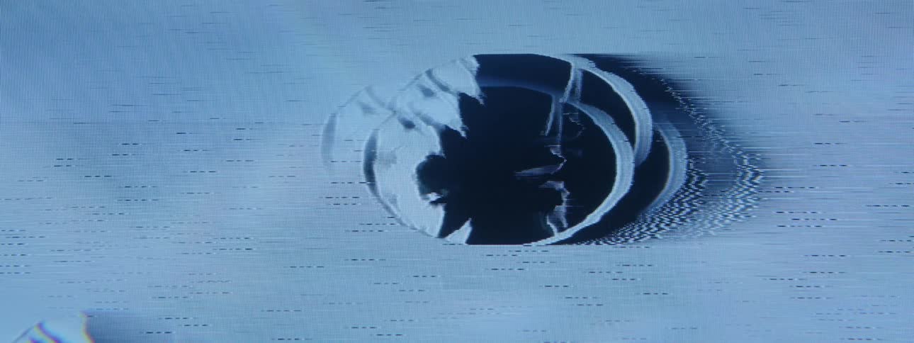 A closeup of a blue screen with a distorted circular area moving up