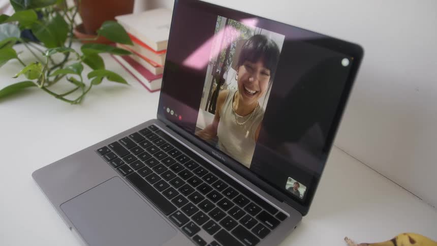 Close up of a laptop screen with a smiling woman appearing on a video call