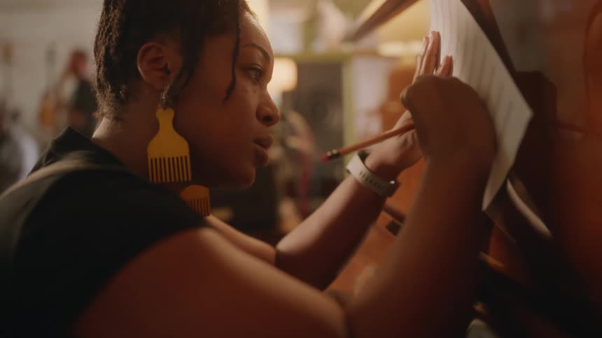 Female musician with a pencil writing on paper at the piano