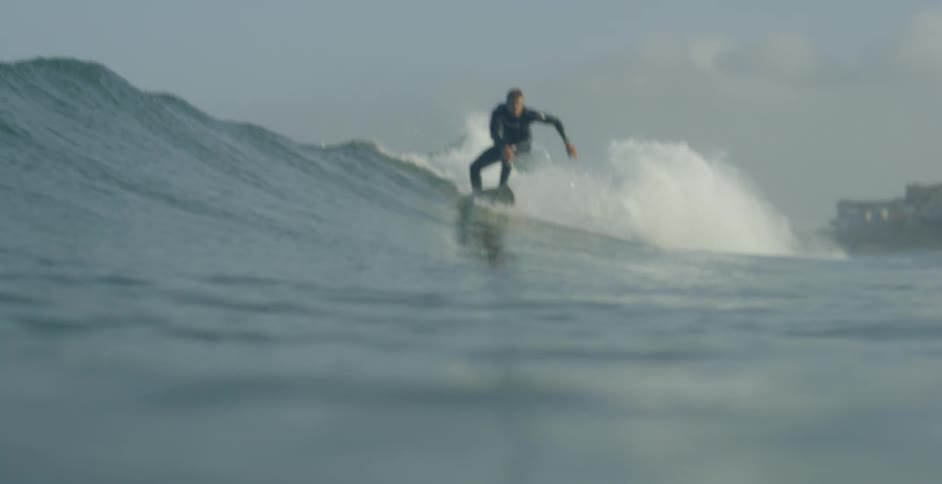 A man begins surfing a wave on his board
