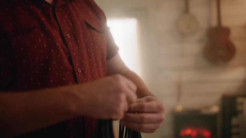 Man in a studio winding a music cable