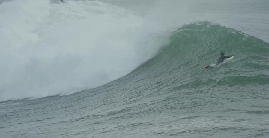 A man dives through a wave in the ocean