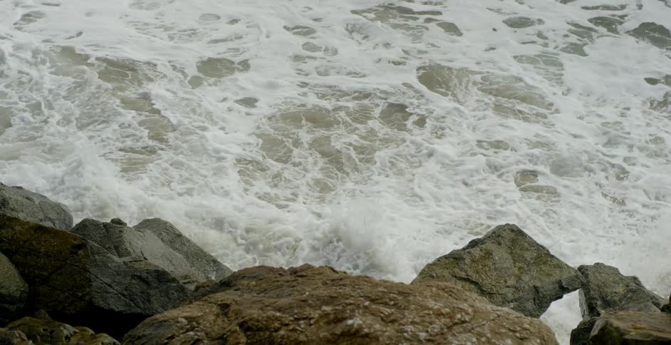 Ocean waves foam and splash against the rocks