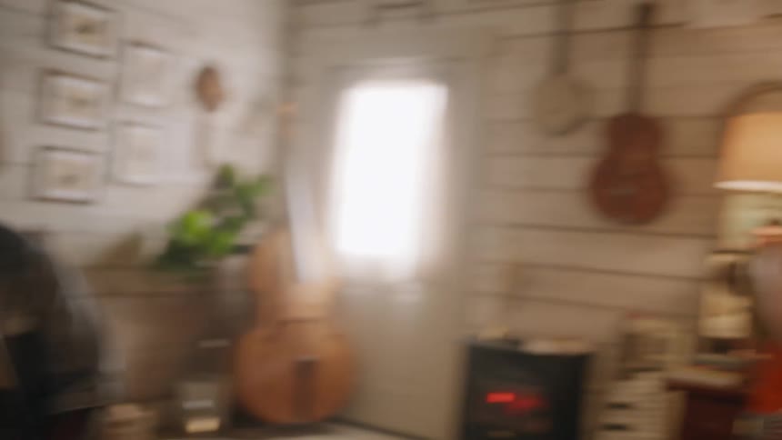 Two men in a studio with one of them playing drums and the other guitar