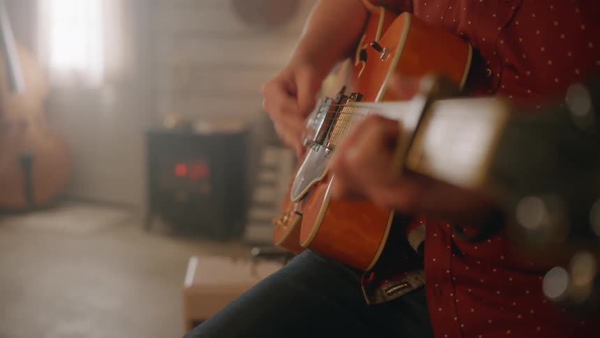 Close up of a musician playing an acoustic guitar
